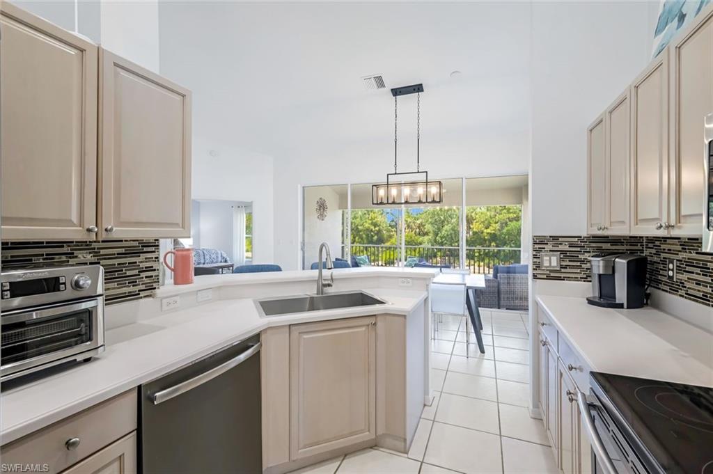 5360 Andover Drive, Unit 202 Naples, FL 34110 - Photo 9 of 25 a kitchen with a sink stove and cabinets
