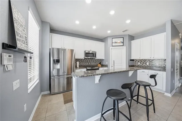 a kitchen with stainless steel appliances a refrigerator stove microwave and cabinets