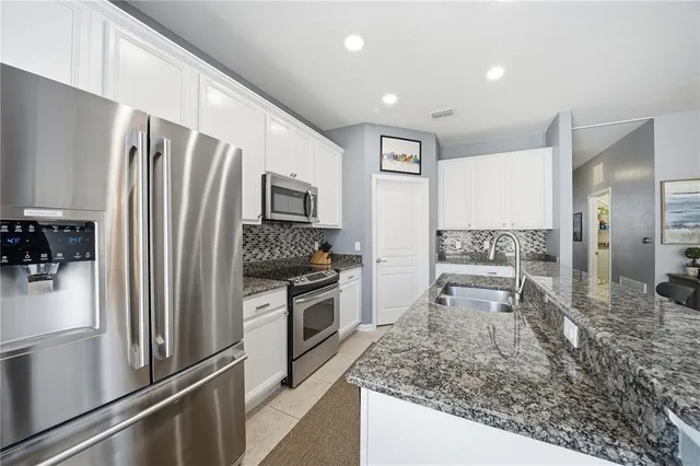 a kitchen with stainless steel appliances granite countertop a refrigerator oven stove a sink and dishwasher