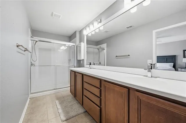 a bathroom with a double vanity sink a mirror and shower