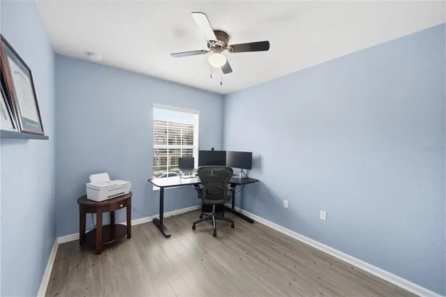 a view of a workspace with furniture and a window