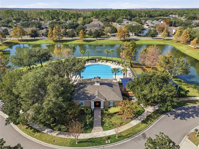 an aerial view of residential houses with outdoor space and lake view