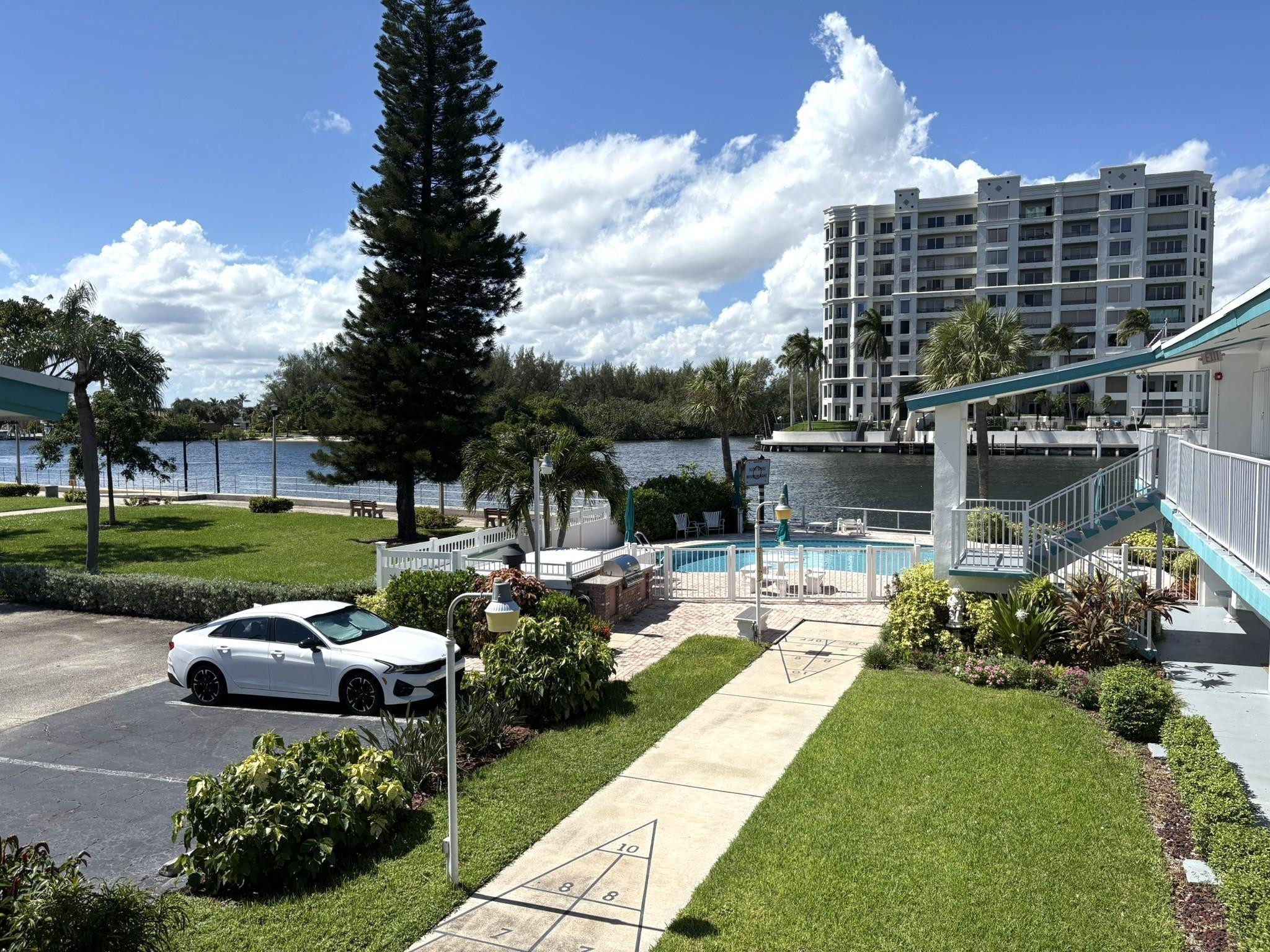 1201 North Riverside Drive, Unit 12B Pompano Beach, FL 33062 - Photo 36 of 63 a view of a swimming pool and lounge chairs in back yard of the house