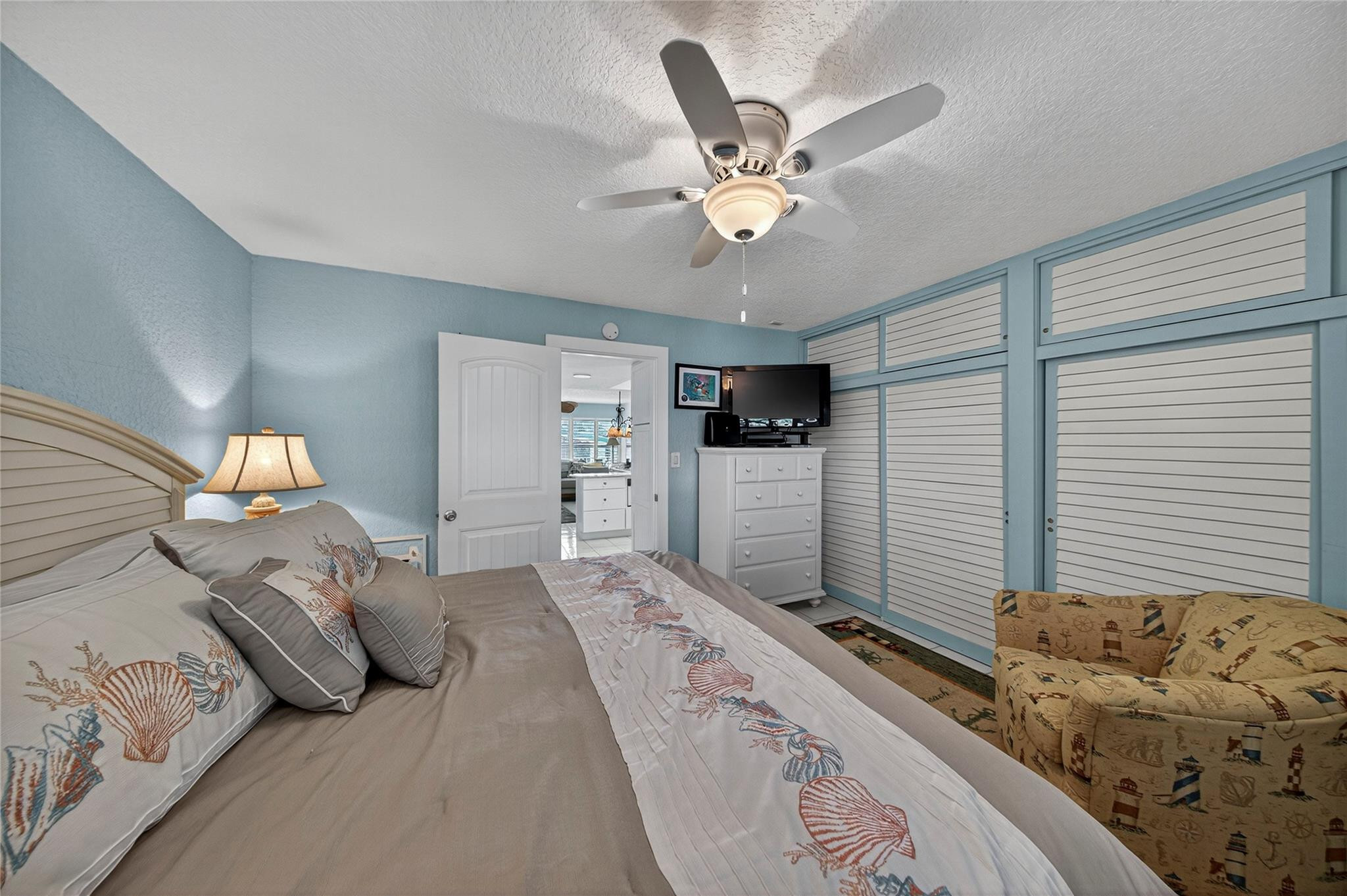 1201 North Riverside Drive, Unit 12B Pompano Beach, FL 33062 - Photo 43 of 63 a bedroom with a large bed and a chandelier