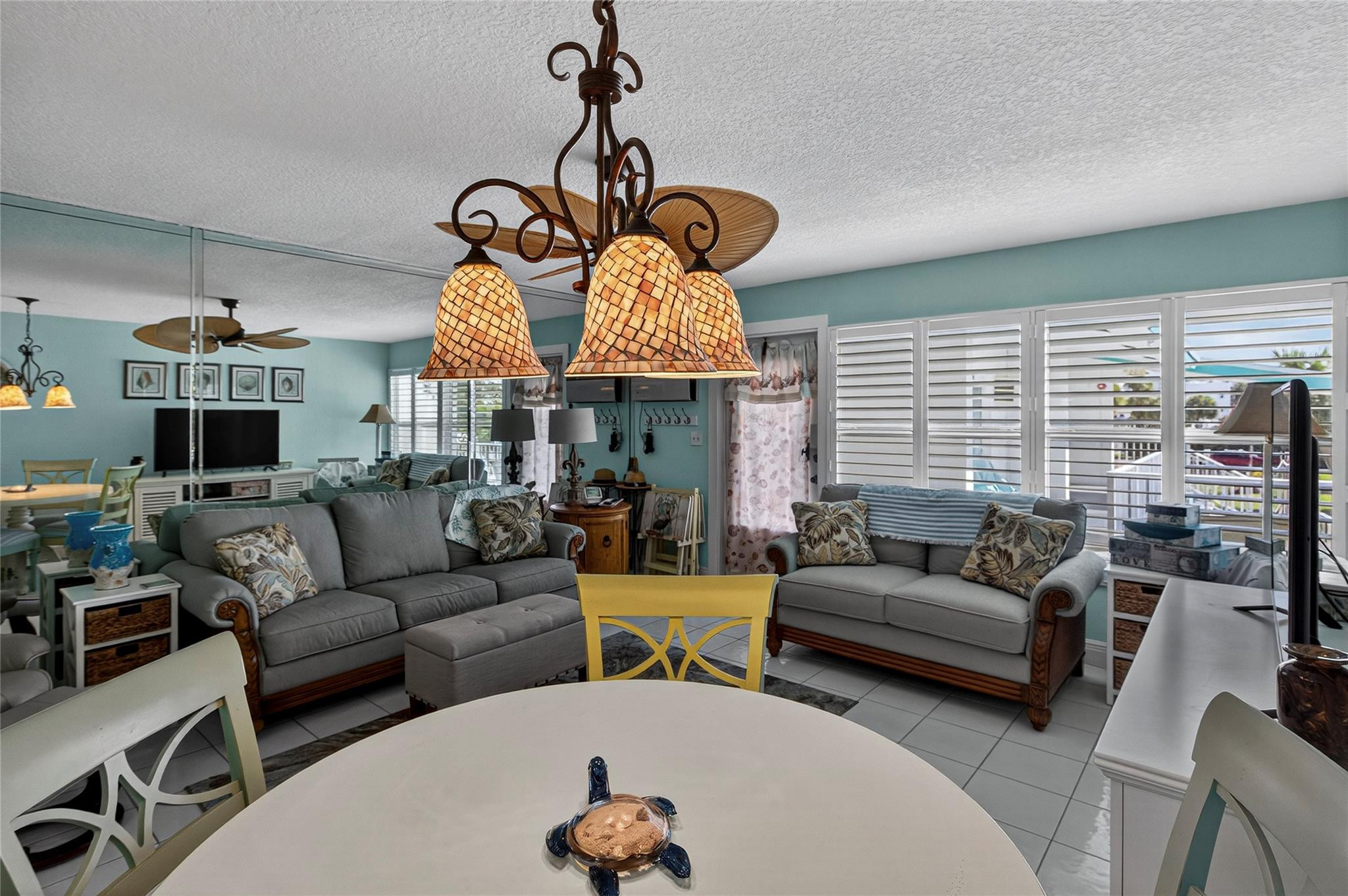 1201 North Riverside Drive, Unit 12B Pompano Beach, FL 33062 - Photo 53 of 63 a living room with furniture a fireplace and a chandelier