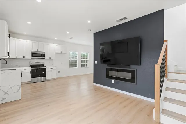 a kitchen with stainless steel appliances kitchen island granite countertop a stove a sink and a microwave