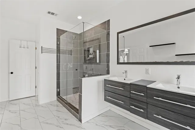 a bathroom with a sink a mirror and a shower