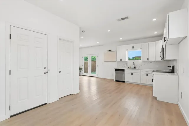 a kitchen with white cabinets and stainless steel appliances