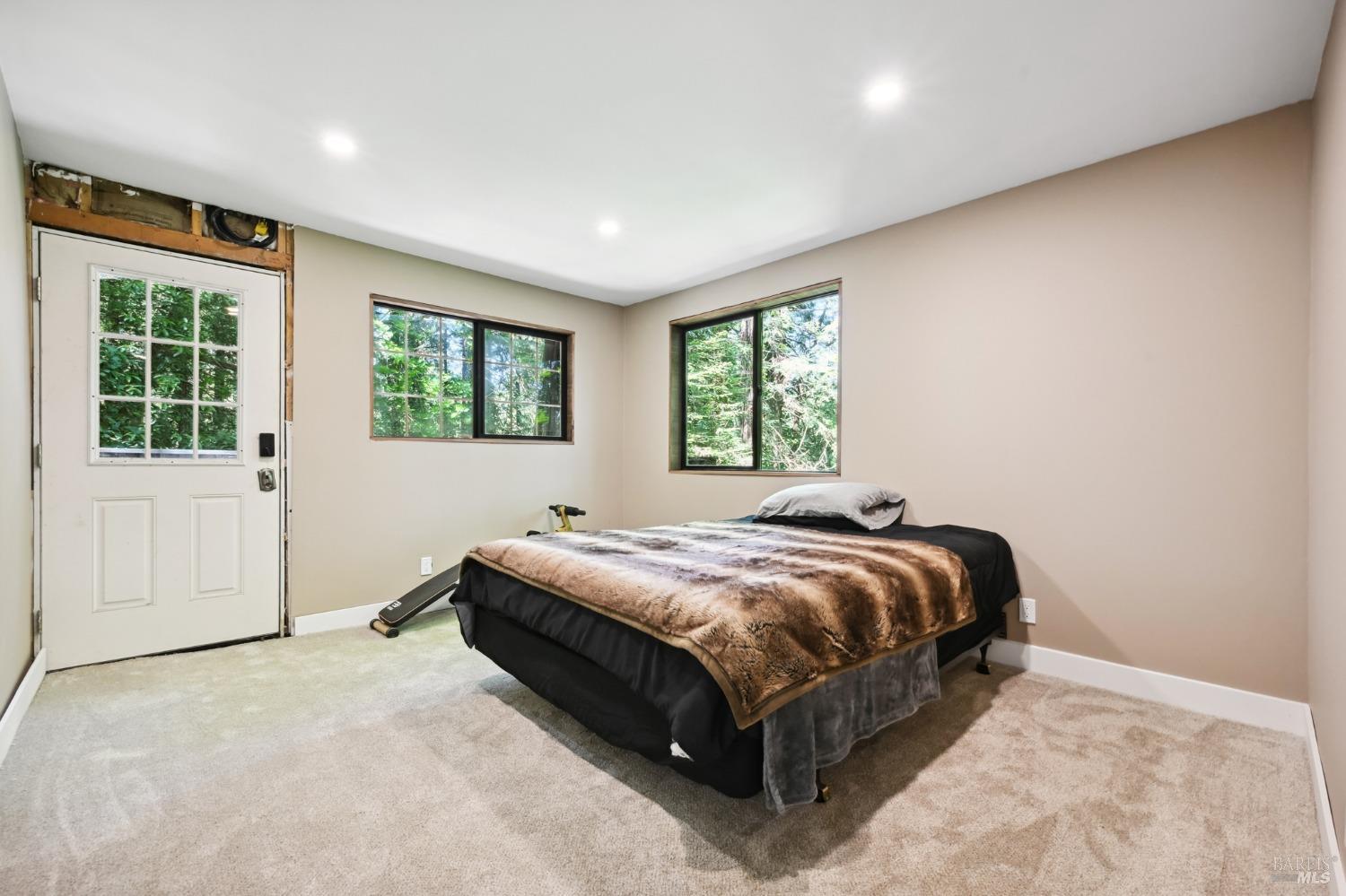 21713 Starrett Hill Drive Monte Rio, CA 95462 - Photo 36 of 50 a bed sitting in a spacious bedroom next to a window