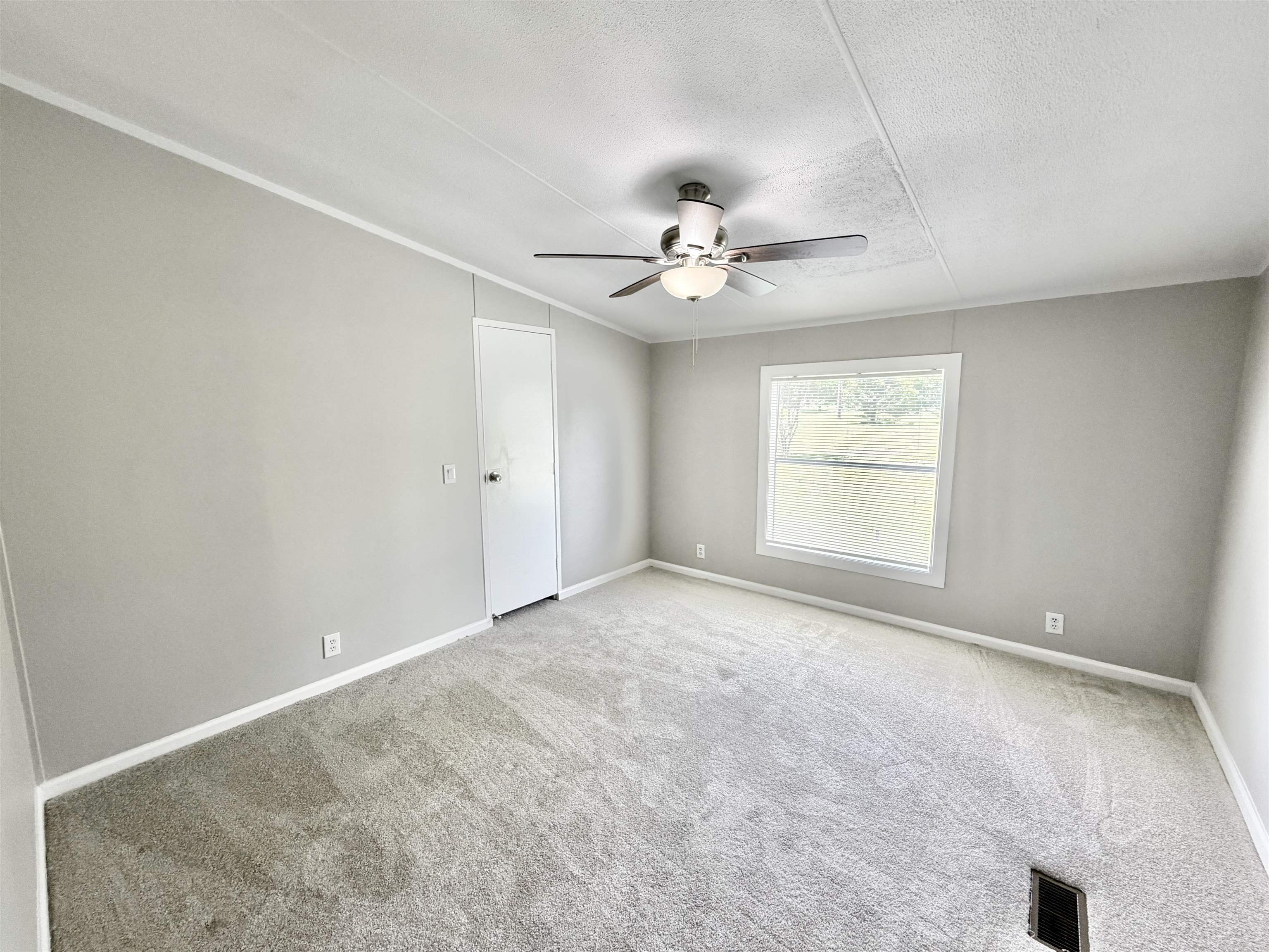 1655 Fayne Road Brighton, TN 38011 - Photo 14 of 28 Light gray interior space featuring a window, light gray carpeting, ceiling fan, and white baseboards