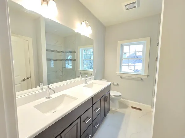 a bathroom with a sink double vanity granite and a bathtub