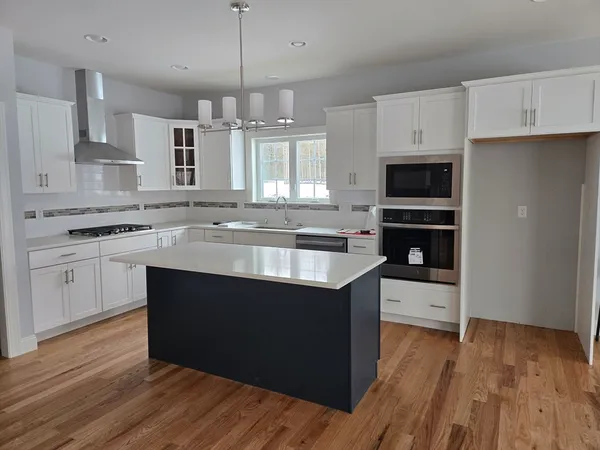 a kitchen with stainless steel appliances granite countertop a sink stove and wooden floor