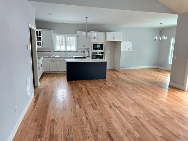 a large kitchen with cabinets wooden floor and stainless steel appliances