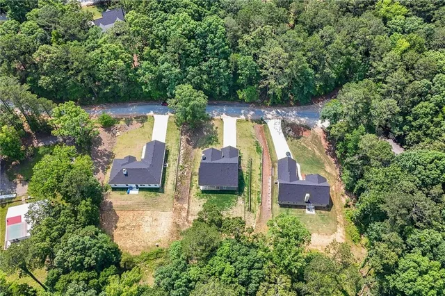 an aerial view of a house with outdoor space pool seating area and trees around