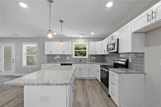 a kitchen with sink stove and cabinets