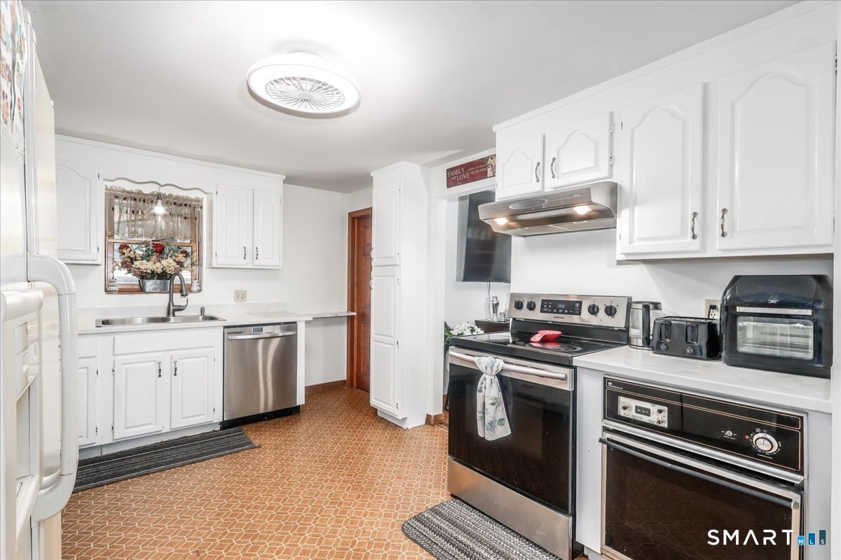 306 Welton Street Hamden, CT 06517 - Photo 12 of 38 a kitchen with granite countertop a sink stove and cabinets