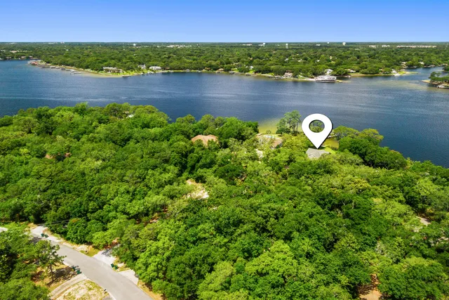 a view of a patio with a table and chairs under an umbrella with a small yard
