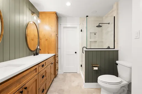 a bathroom with a sink a toilet and a mirror