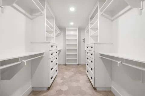 a view of walk in closet with empty racks