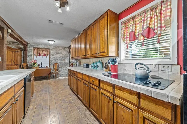 a kitchen with sink a stove and cabinets