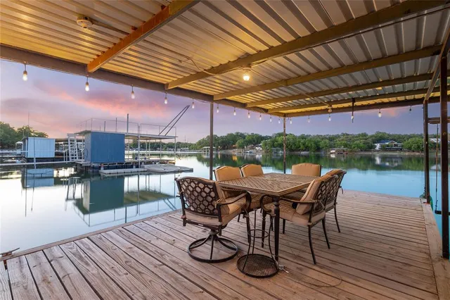 a patio with wooden floor a yard tables and chairs
