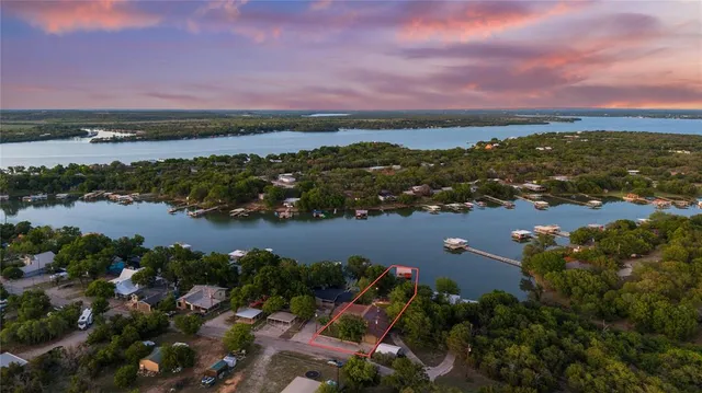 an aerial view of city and lake with trees all around
