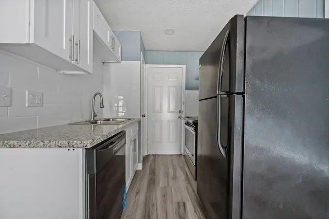 a kitchen with stainless steel appliances granite countertop a refrigerator and a sink