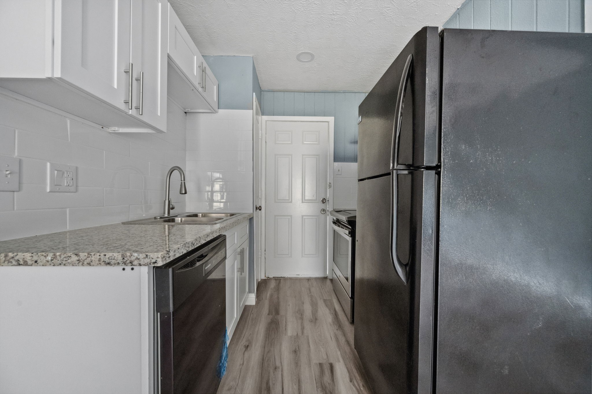 3425 Nettleton Street, Unit 1 Houston, TX 77004 - Photo 6 of 12 a kitchen with stainless steel appliances granite countertop a refrigerator and a sink