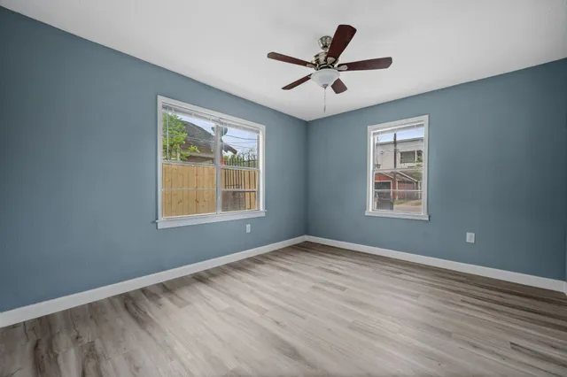 a view of a big room with wooden floor and windows