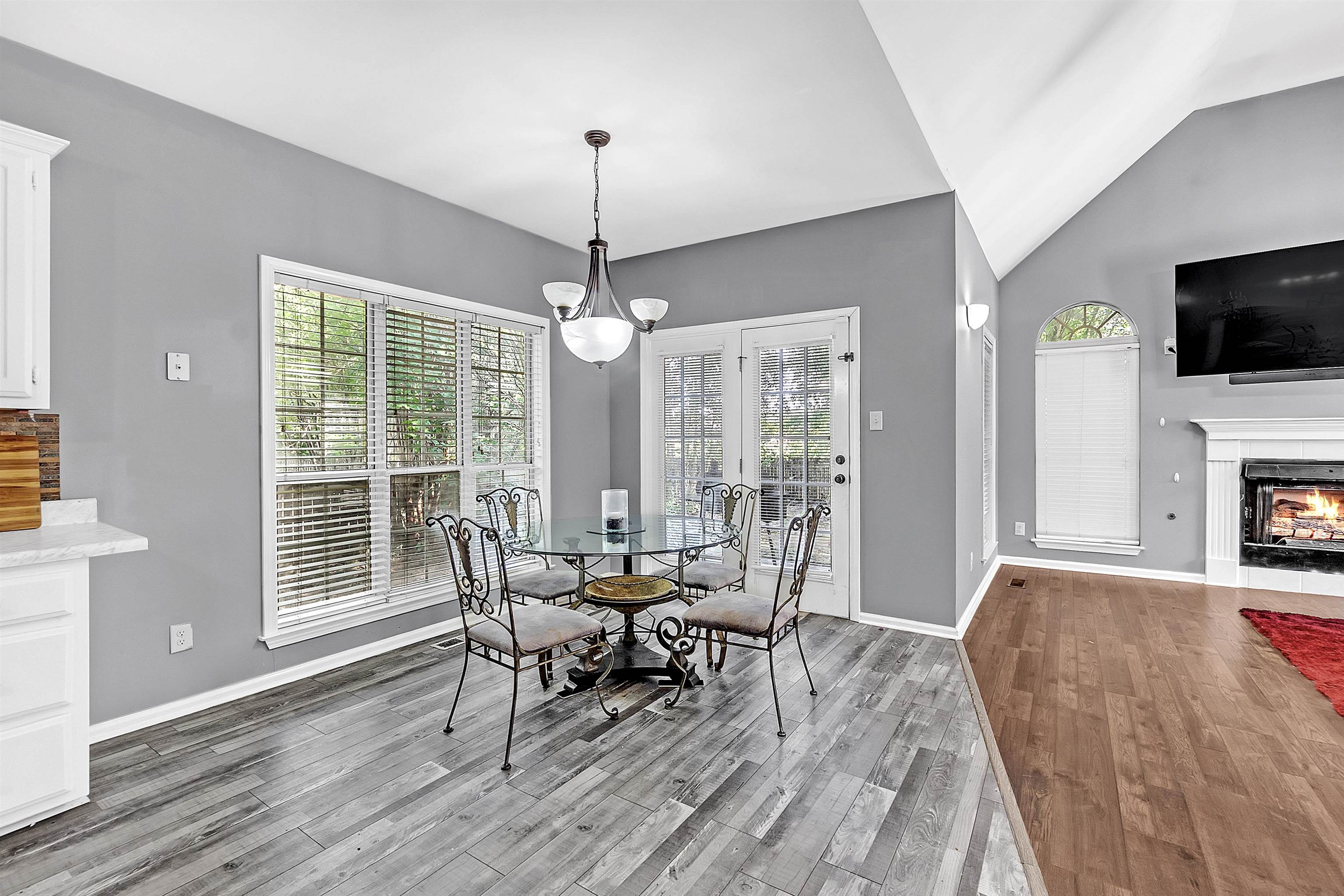 4366 Campground Road Munford, TN 38058 - Photo 12 of 40 Dining area featuring a warm lit fireplace, light wood finished floors, lofted ceiling, and a chandelier