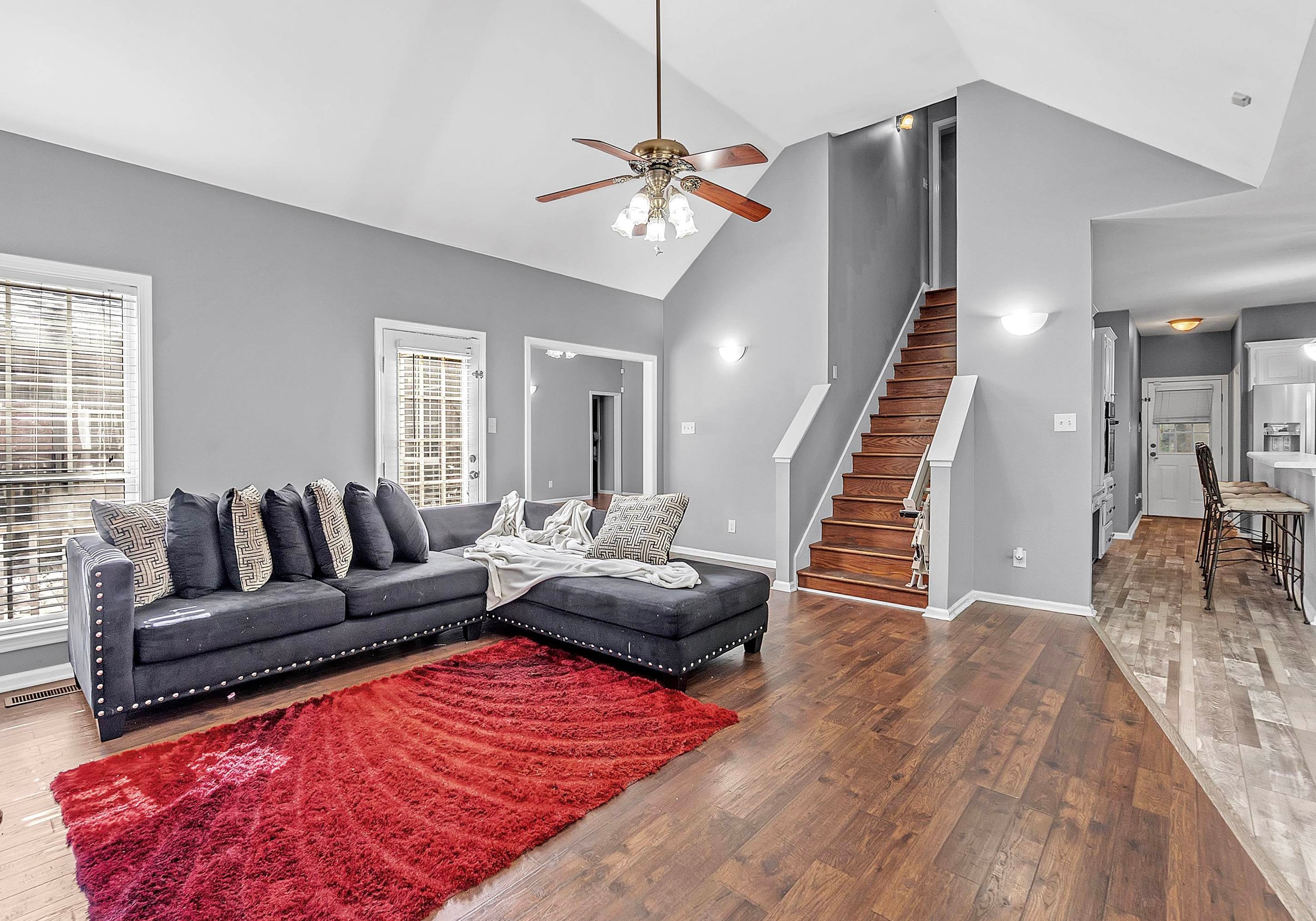 4366 Campground Road Munford, TN 38058 - Photo 13 of 40 Hearth room featuring high vaulted ceiling with plenty of natural light, fireplace, wood finished floors, stairway leading to the Bonus/4th Bedroom and Full Bath