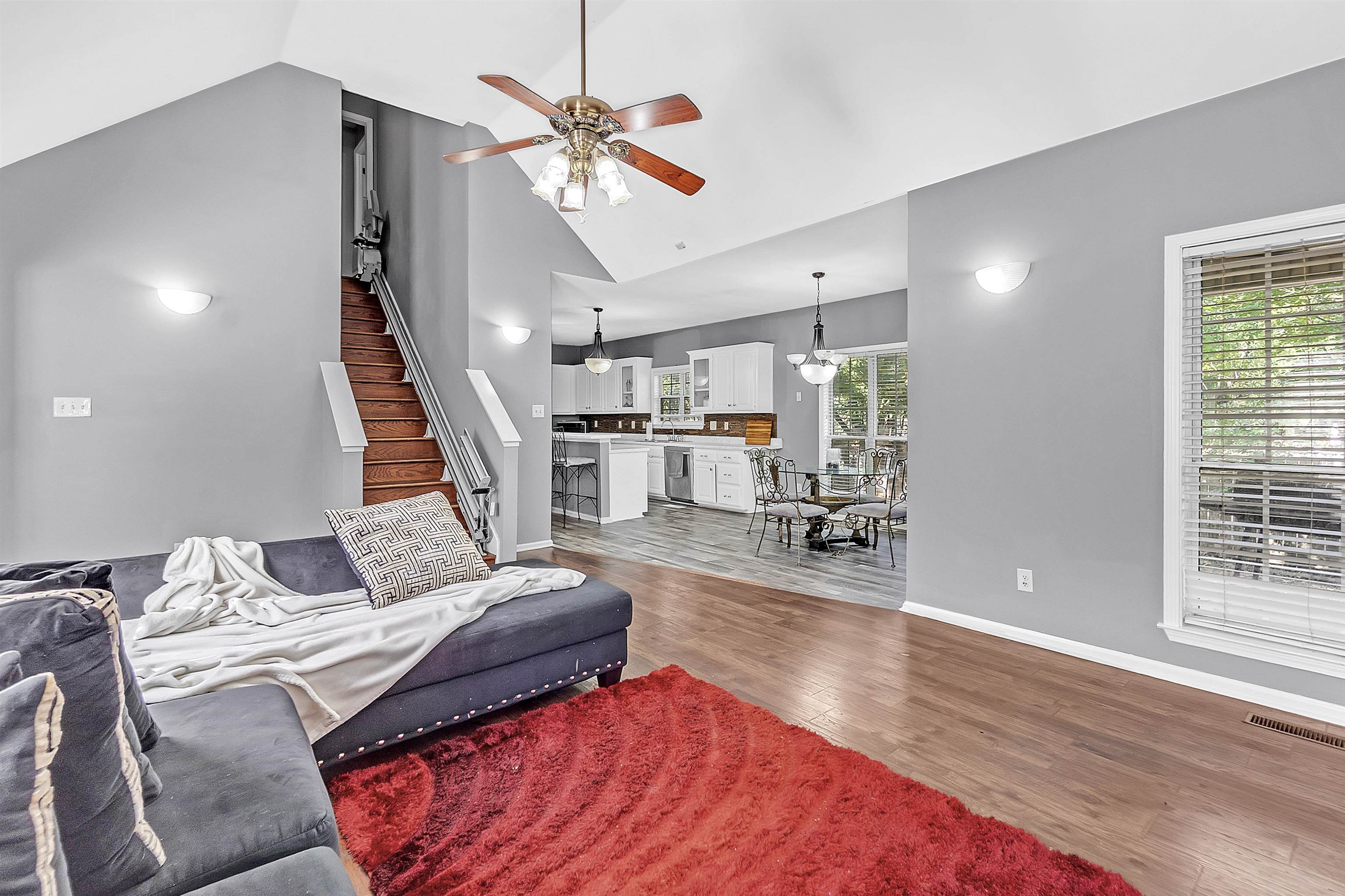 4366 Campground Road Munford, TN 38058 - Photo 14 of 40 Hearth room featuring high vaulted ceiling with plenty of natural light, fireplace, wood finished floors, stairway leading to the Bonus/4th Bedroom and Full Bath