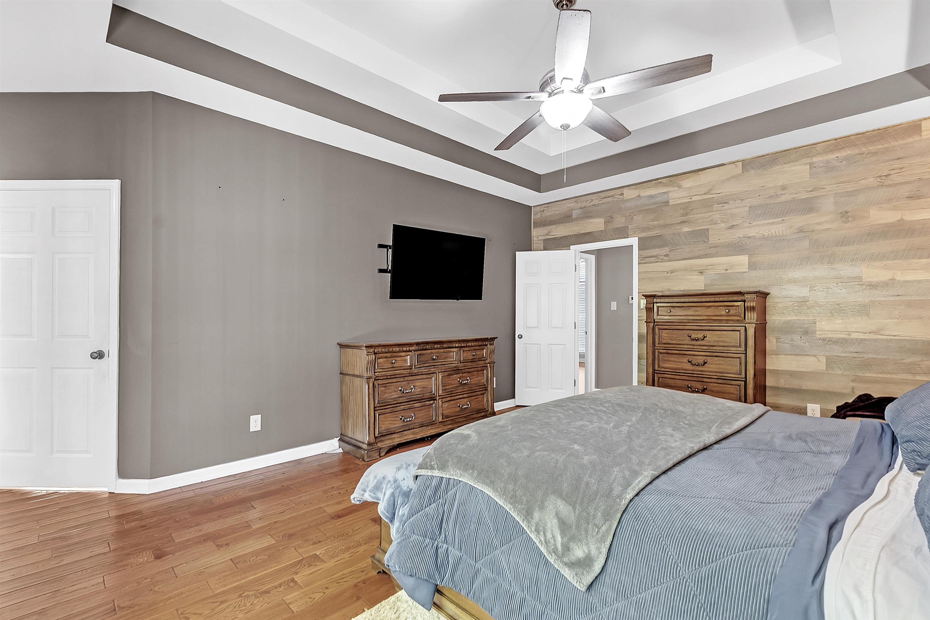 4366 Campground Road Munford, TN 38058 - Photo 19 of 40 Bedroom with a raised ceiling, wood finished floors, wooden walls, and a ceiling fan