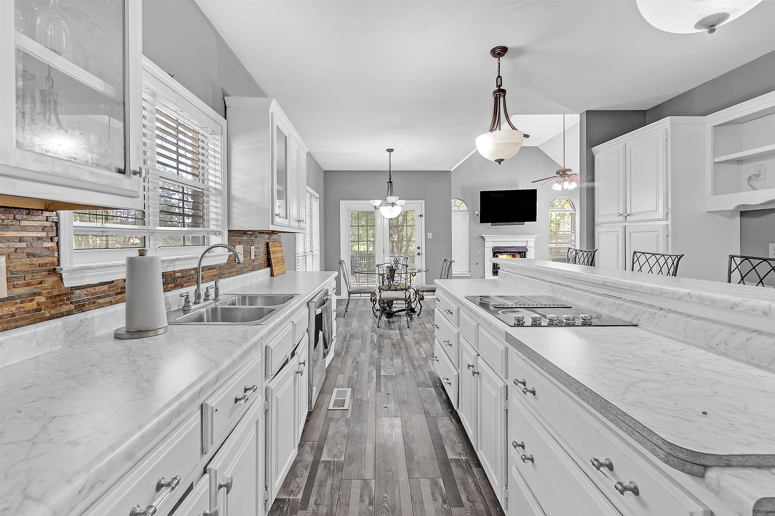 4366 Campground Road Munford, TN 38058 - Photo 9 of 40 Kitchen with white cabinetry, a glass covered fireplace, healthy amount of natural light, and decorative light fixtures