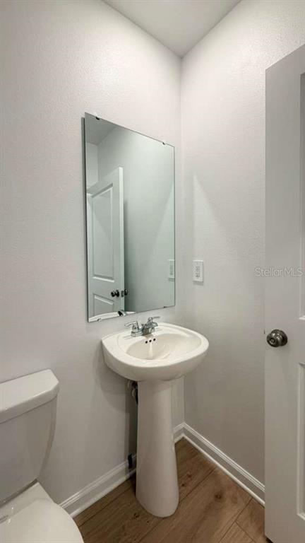 5174 Clay Whaley Road St. Cloud, FL 34772 - Photo 10 of 25 a bathroom with a toilet sink and mirror