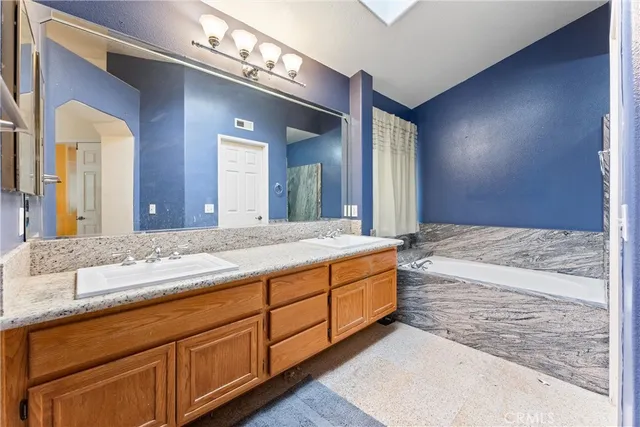 a spacious bathroom with a granite countertop sink and a large mirror