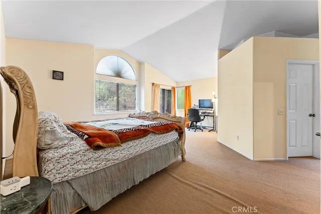 a bedroom with a bed and a large mirror on the dresser