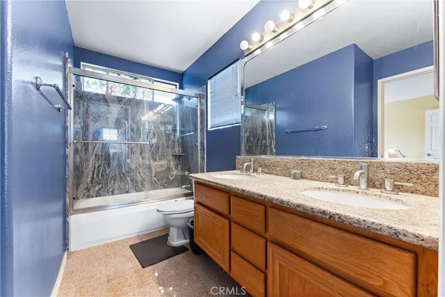 a bathroom with a granite countertop sink a large mirror and a bathtub