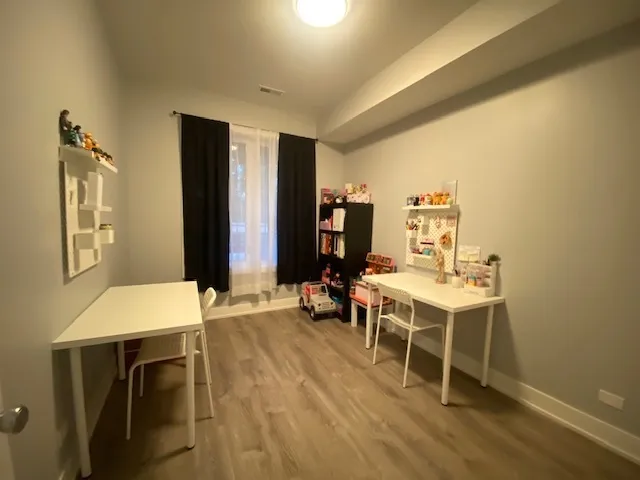 a room with a table chairs and a refrigerator