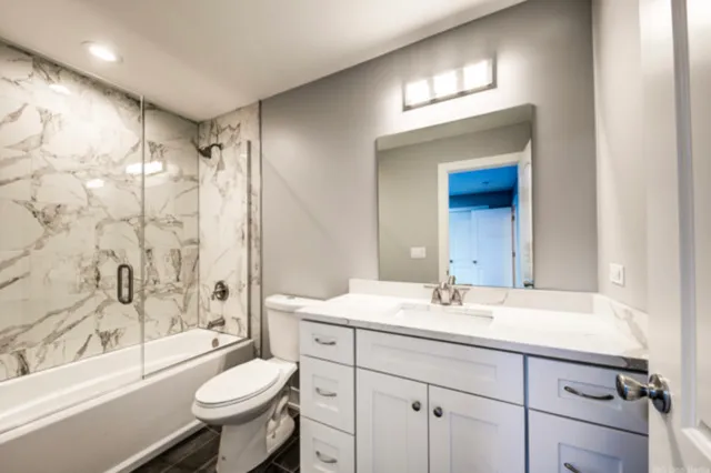 a bathroom with a sink toilet a mirror and shower