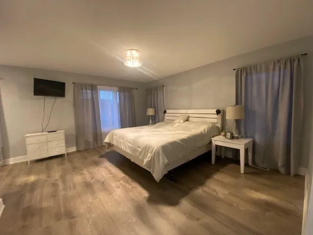 a bed sitting in a spacious bedroom next to a window