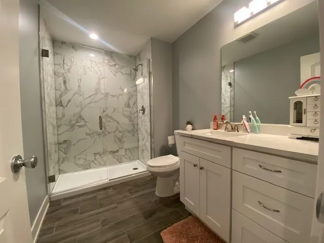 a bathroom with a double vanity sink toilet and shower