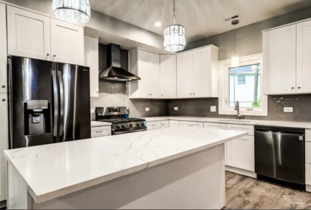 a kitchen with stainless steel appliances granite countertop a sink stove and refrigerator