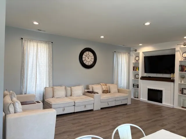a living room with furniture a flat screen tv and a fireplace