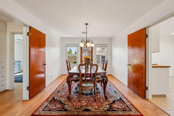 a dining room with furniture window and wooden floor