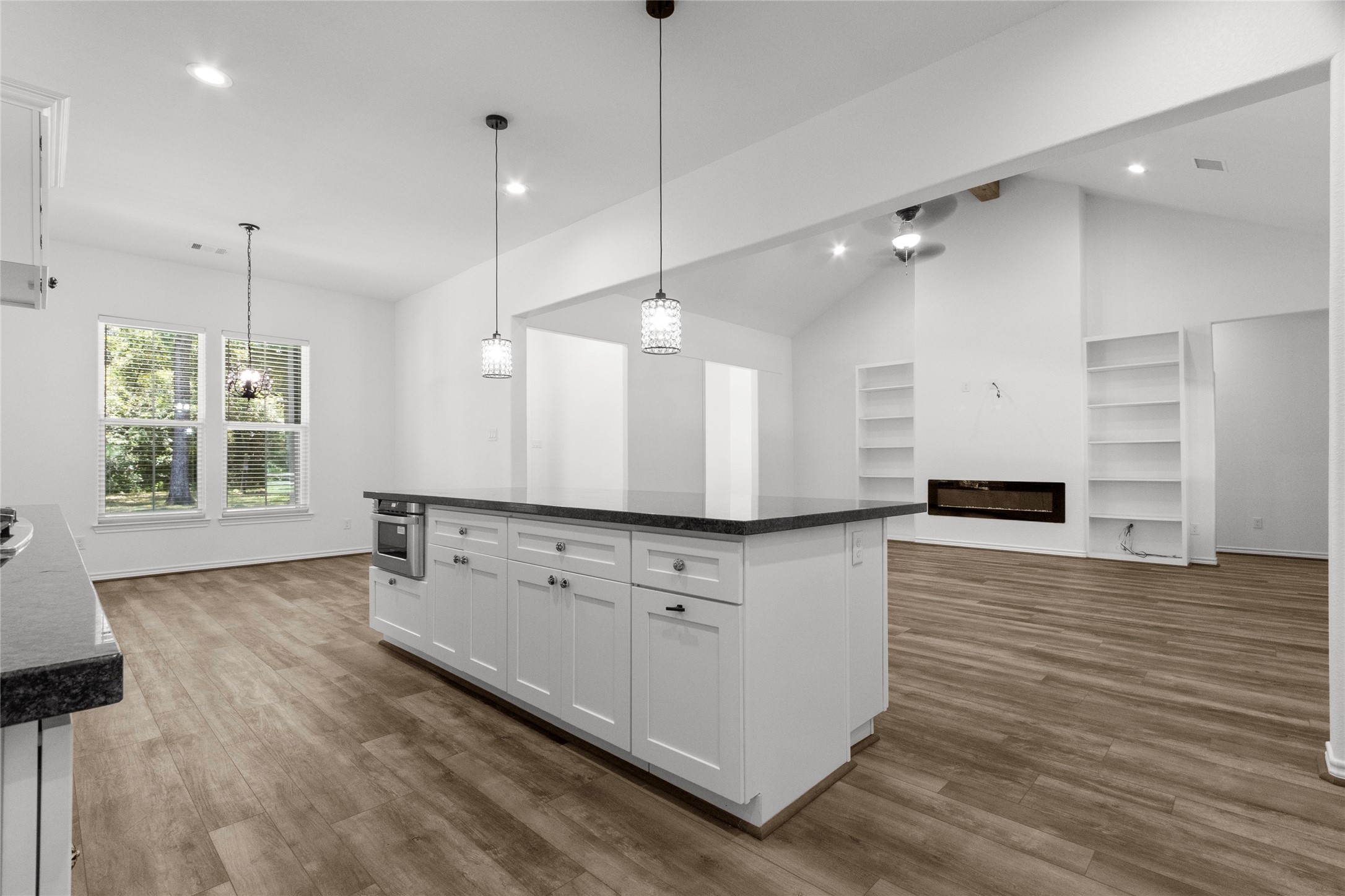 16735 Azalea Lane Plantersville, TX 77363 - Photo 12 of 44 a view of a kitchen with kitchen island a sink wooden floor and window