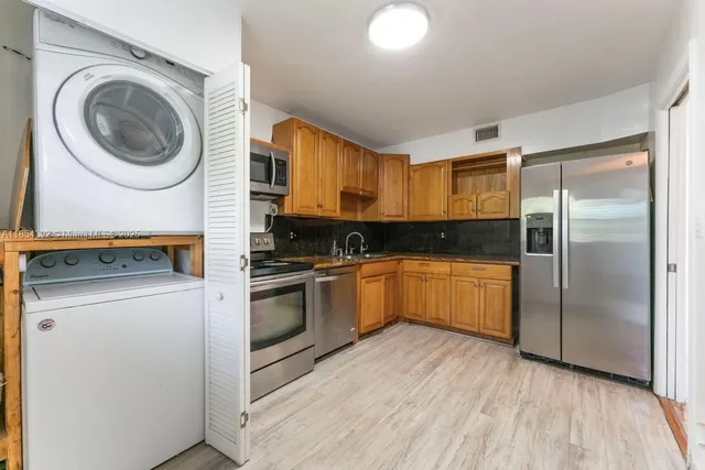 a kitchen with a refrigerator sink and cabinets