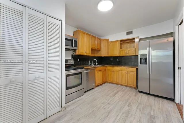 a kitchen with a refrigerator and a sink