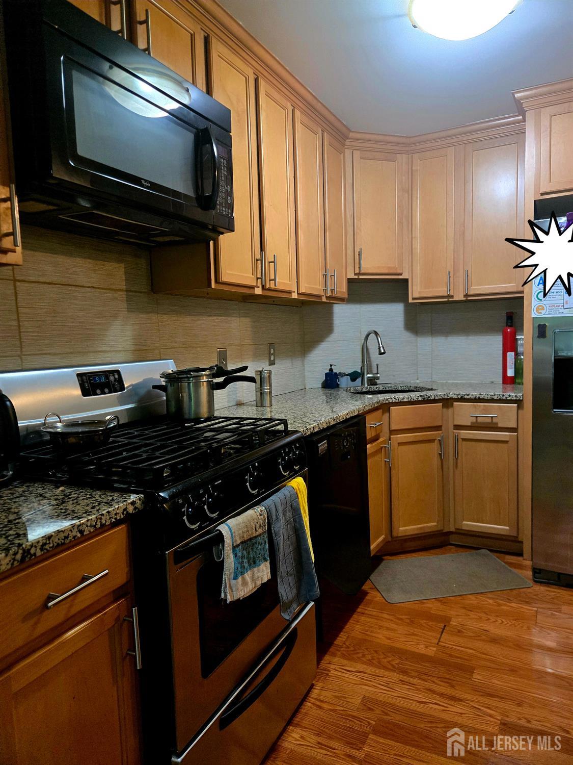 201 Prestwick Way Edison, NJ 08820 - Photo 11 of 21 a kitchen with stainless steel appliances granite countertop a stove a sink and a microwave