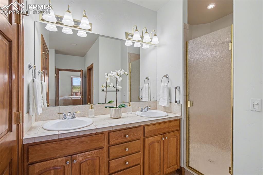 4215 Star Ranch Road Colorado Springs, CO 80906 - Photo 7 of 44 a bathroom with double vanity sinks a toilet a mirror and shower
